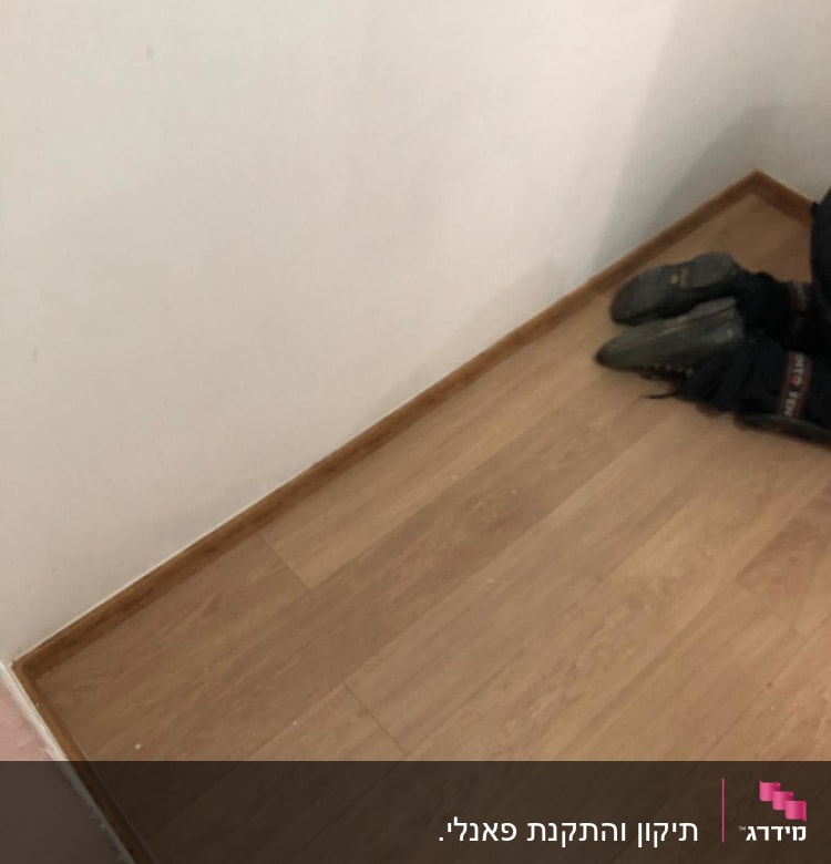 רצפת פרקט עץ עם קיר לבן